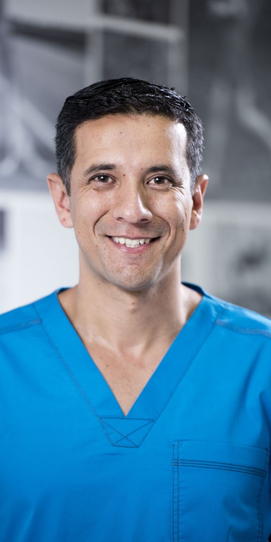 Mauricio Marín Ulloa, fisioterapeuta, con su uniforme azul en la clínica.